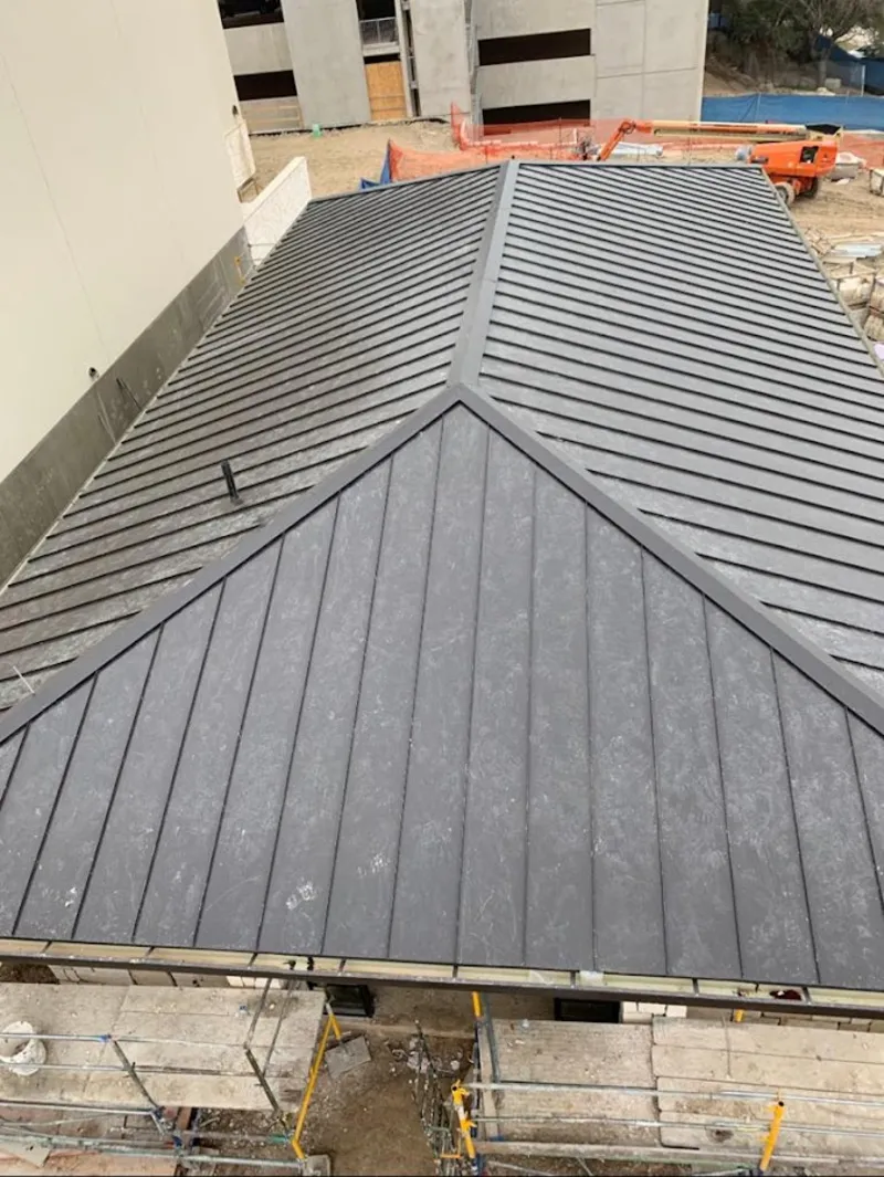 Commercial metal roof construction with crane equipment in Hampton